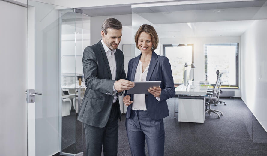 man and woman holding a tablet