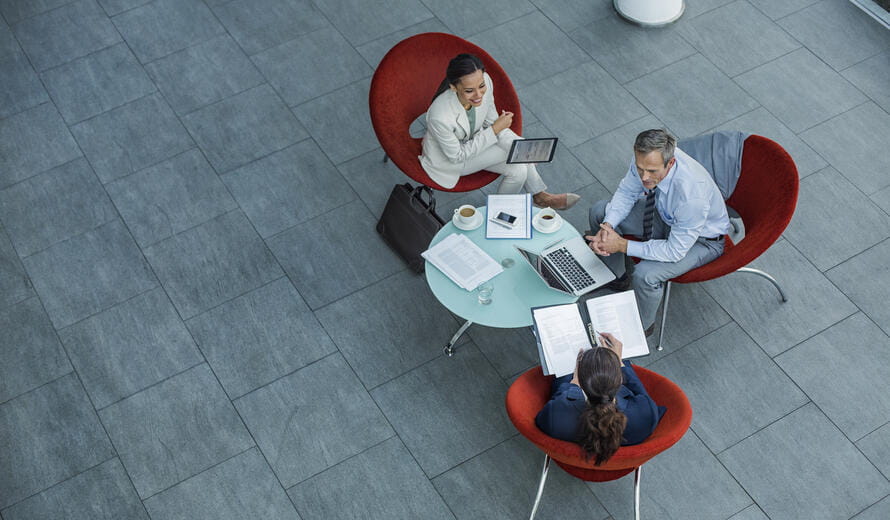 High angle view of businesspeople discussing strategy at coffee table in office