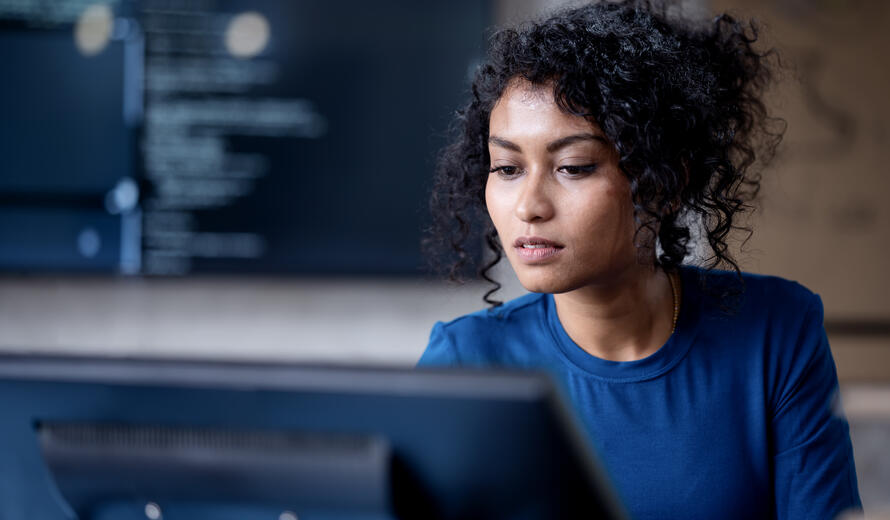 a woman with her hair uo looking at a computer