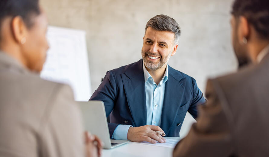 a man smiling in a meeting