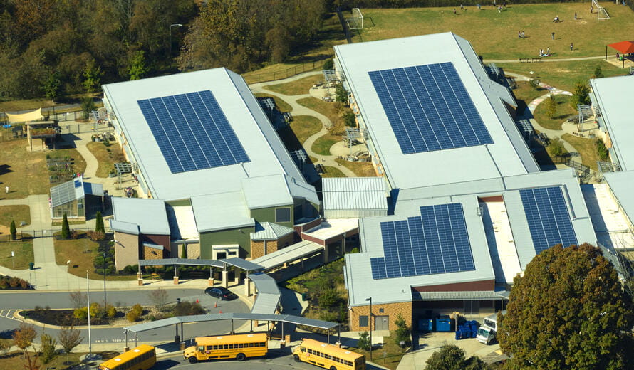 Roof of american school building covered with photovoltaic solar panels for production of electric energy