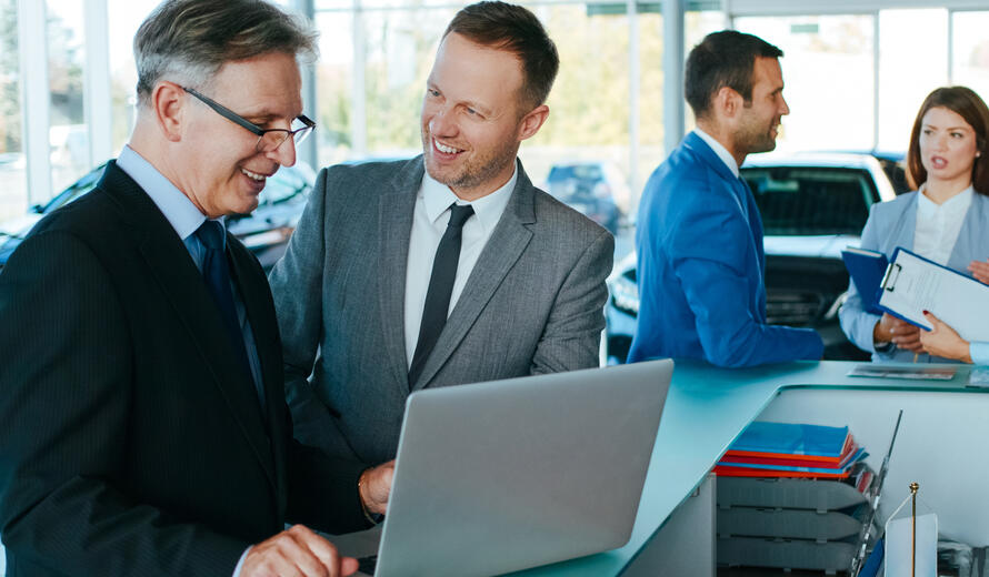 men in ties at a dealership