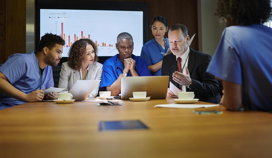 healthcare workers around a laptop