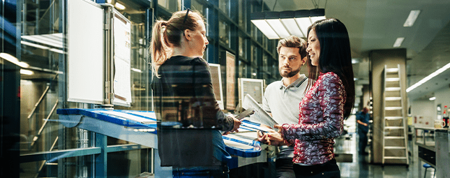 people discussing plans at a drafting table